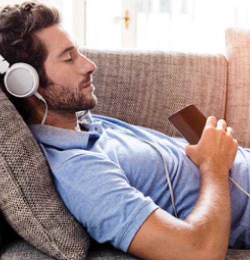 Man with headphones relaxing on sofa