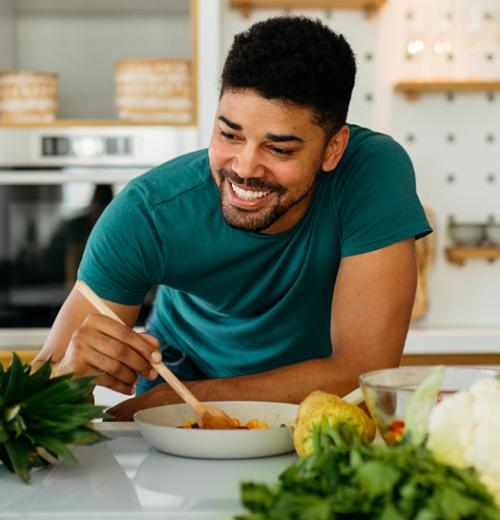Man eating salad in kitchen